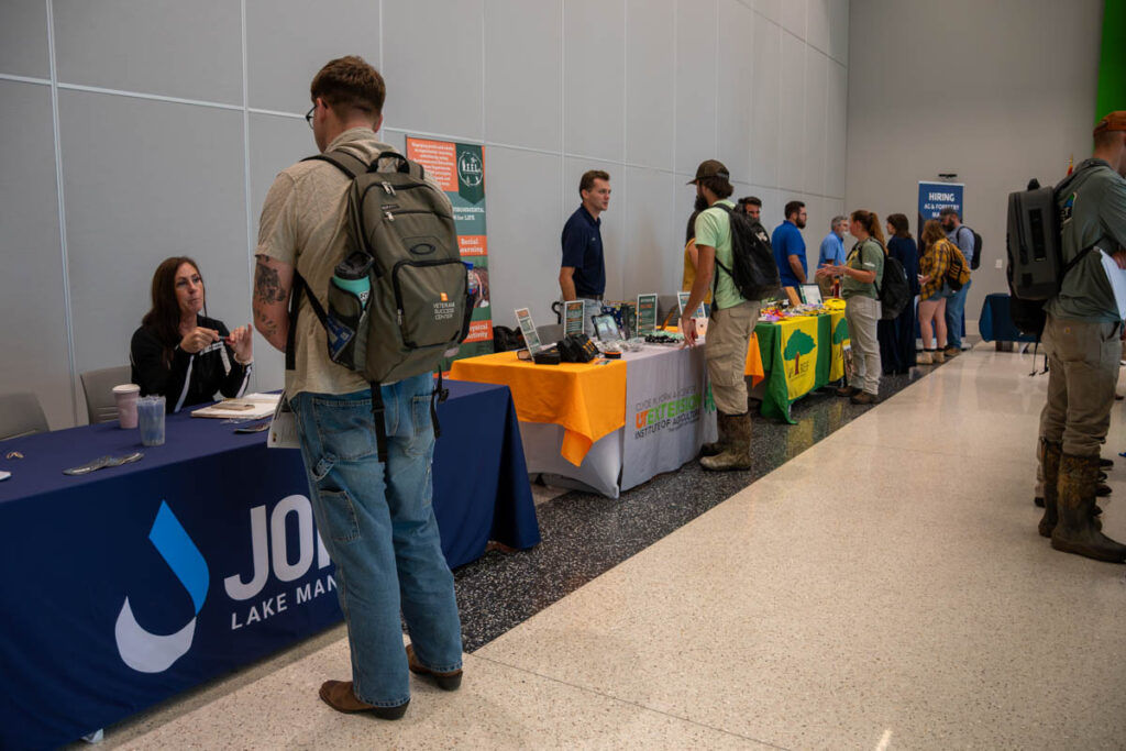 Nine people stand around tables in a building on the UT Institute of Agriculture campus.