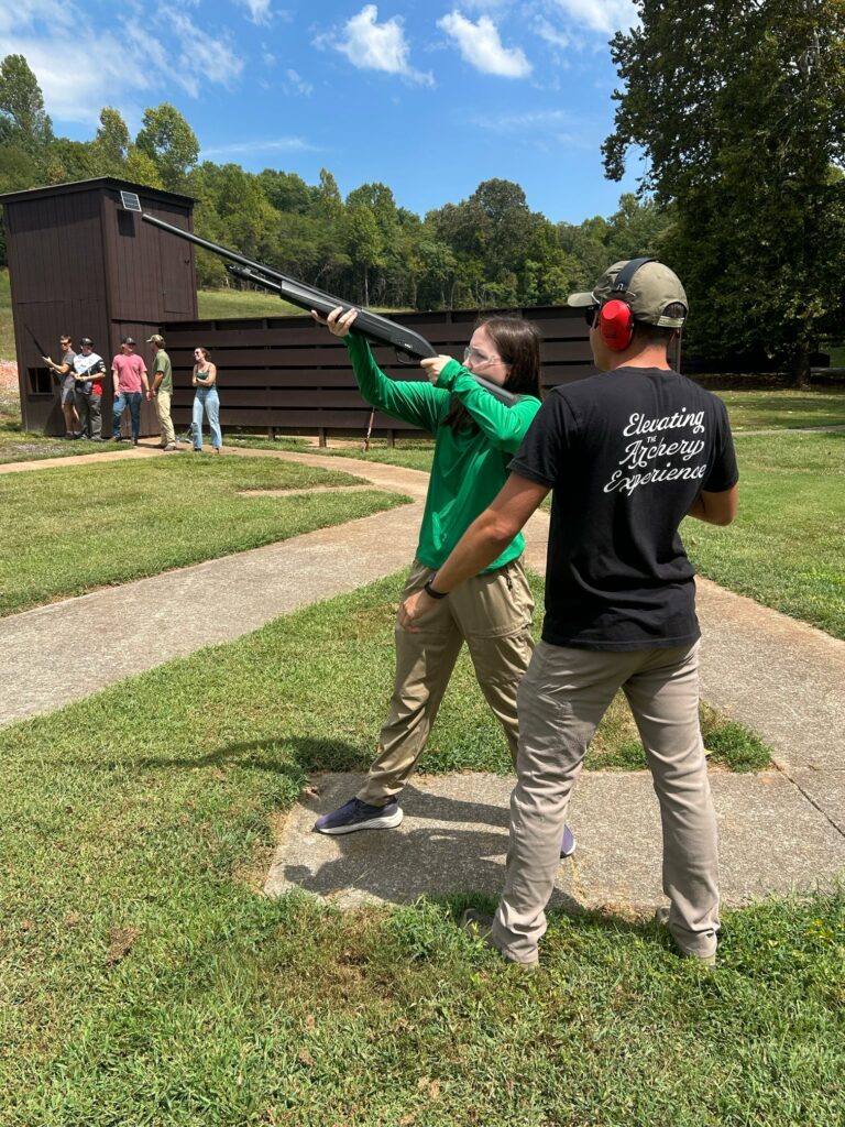 One person instructs another on shooting a gun.