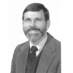 Black and white photo of man in tie and suit.