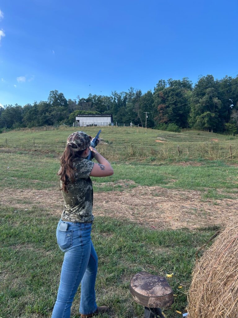 Person aims gun into field.